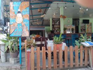 a wooden fence in front of a restaurant with plants at Ning Ning Bungalow in Don Det