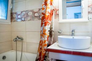 a bathroom with a sink and a shower curtain at angelikashouse,big house in Corfu Town