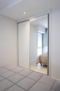 um quarto com portas de vidro deslizantes e uma cama em Departamento de un dormitorio - SAN LORENZO em Santa Fé