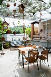 a patio with a table and chairs and a bird house at angelikashouse,big house in Corfu Town