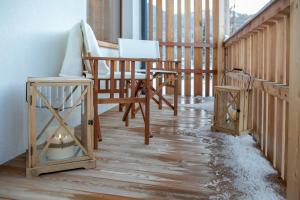 a porch with a chair and a desk with snow on the floor at Chalet del Capriolo in Vodo Cadore