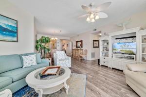 uma sala de estar com um sofá e uma mesa em Beach Colony East 13C em Perdido Key