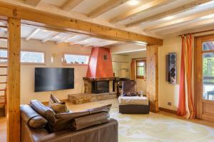 sala de estar con sofá y chimenea en Chalet Galadhrim Chamonix Mont Blanc Valley en Les Houches