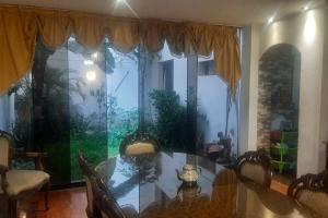 a dining room with a table and a large window at Amplio Departamento Residencial en La Molina in Lima