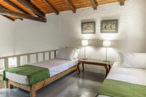 a bedroom with two beds and a table with two lamps at Dimoulitsa Villas Complex in Doukádes