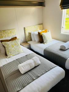 Habitación con 2 camas con almohadas en Lazy Bunny Lodge with Hot Tub, en Malton