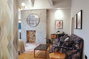 a living room with a couch and a brick fireplace at The Brownswood in London