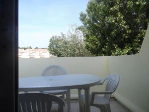 a table and chairs on a patio with a window at marseillan plage super appart in Marseillan