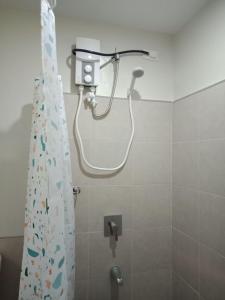een douche in een badkamer met een douchegordijn bij Cozy1233 studio at The Persimmon in Cebu City