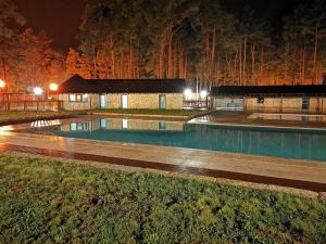 una piscina frente a un edificio por la noche en Alvão Village & Camping 