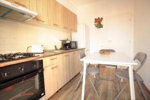kuchnia ze stołem, kuchenką, stołem i krzesłami w obiekcie New Central Luxury Oasis w Klużu-Napoce