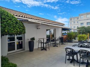a patio with tables and chairs and a bar at Kyriad Montpellier Sud - A709 in Montpellier