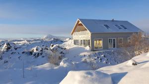una casa en la nieve con suelo cubierto de nieve en Slow Travel Mývatn - Þúfa - Private Homestay en Myvatn