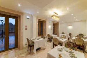 un restaurant avec des tables et des chaises blanches et un lustre dans l'établissement Sintra Marmòris Camélia, à Sintra