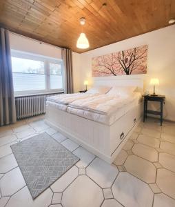 a bedroom with a large white bed and a window at Ferienwohnung Meyer in Surwold