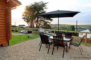 a table and chairs with an umbrella on a patio at CROYDE RANCH CHALET 2 Bedrooms in Croyde