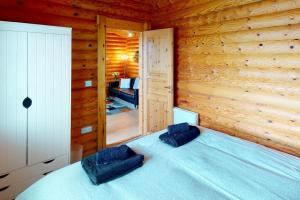 ein Schlafzimmer mit einem blauen Bett in einem Blockhaus in der Unterkunft CROYDE RANCH CHALET 2 Bedrooms in Croyde
