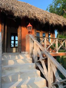 喀巴里特的住宿－Surfbreak B&B，茅草屋顶和楼梯位于前面的房子