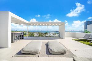マイアミにあるNomada Destination Residences - Quadroの建物の屋上に枕2つ付きのパティオ