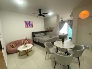 Teega Suites, Puteri Harbour, Iskandar Puteri في نوساجايا: غرفة معيشة مع سرير وأريكة وطاولات