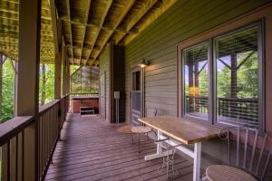 a porch with a wooden table and chairs on it at Little Bear Lodge in Blowing Rock