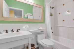 a bathroom with a toilet and a sink and a mirror at Dove Creek Resort & Marina, Trademark Collection by Wyndham in Key Largo