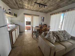 sala de estar con sofá y mesa en Les Diablettes, en Punta del Diablo