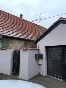 una casa bianca con una porta e un tetto di Le Megève a Sainte-Croix-en-Plaine Altre 8 foto