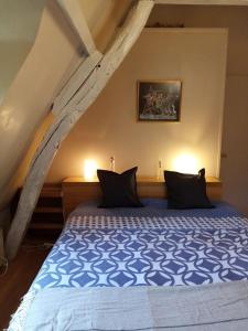 1 dormitorio con 1 cama con sábanas azules y blancas en Longère les pieds dans l eau, en Saint-Philbert-sur-Risle