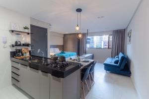 uma cozinha com um lavatório e um fogão num quarto em Mardisa Design - Luxo e Requinte em Cabo Branco por Carpediem em João Pessoa