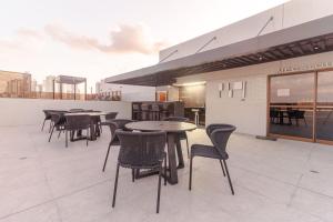 um pátio com mesas e cadeiras num edifício em Mardisa Design - Luxo e Requinte em Cabo Branco por Carpediem em João Pessoa