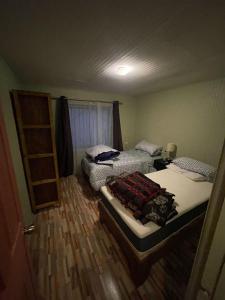 a bedroom with two beds and a ladder at Casa amoblada en Coronel in Concepción