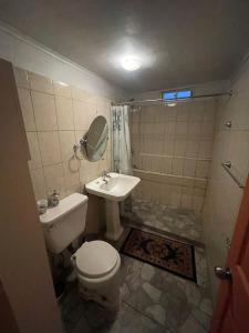 a bathroom with a toilet and a sink at Casa amoblada en Coronel in Concepción
