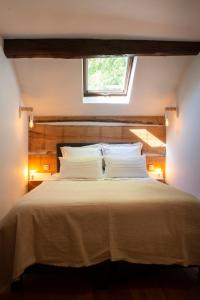 Schlafzimmer mit einem großen weißen Bett und einem Fenster in der Unterkunft Le Marronnier in La-Roche-en-Ardenne