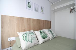 a bedroom with a bed with green and white pillows at loft con office santander in Santander