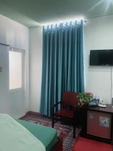 1 dormitorio con 1 cama, 1 silla y 1 ventana en Nhà nghỉ Phương Dung en Phu Quoc