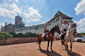 zwei Frauen reiten vor einem Schloss in der Unterkunft Schöne Ferienwohnung „Zum Glück“ in Eisenach