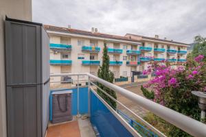 einen Balkon mit blauen und weißen Gebäuden und Blumen in der Unterkunft Apartamento Merida in Alcanar