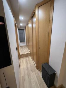 um corredor vazio com uma porta e um piso de madeira em Encantador Apartamento en pleno Centro em Jaén