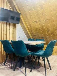 a table and chairs in a room with wooden ceilings at Gąsienicowy Widok in Poronin