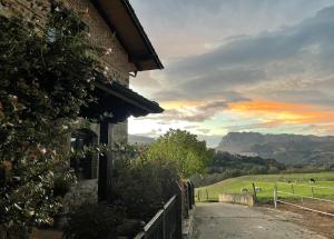 un edificio con vistas a un campo y a las montañas en Vitori's House Tourist Accommodation, en Ahedo