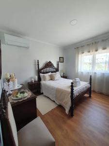 Alojamento Local Terreiro في بومبال: غرفة نوم بسرير وطاولة واريكة