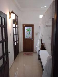 a hallway with a room with a door and a bed at Prasai House in Ahangama