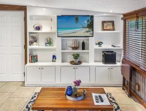 a living room with white shelves and a tv at Island Hideout in Charleston