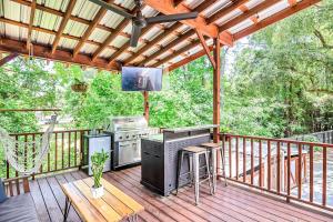 a screened in deck with a stove and a television at Island Nest in Charleston