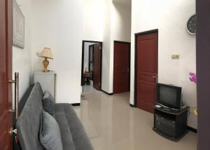 - un salon avec un canapé et une télévision dans l'établissement Homestay Syariah Orchard Family D30, à Sengkaling