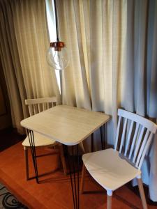 una mesa y dos sillas frente a una cortina en Hotel Lido en General Rodríguez