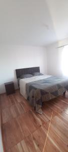 a bedroom with a bed and a wooden floor at Piscinas y cabañas san antonio in Los Ángeles