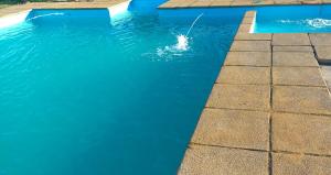 a person in a pool with blue water at Piscinas y cabañas san antonio in Los Ángeles