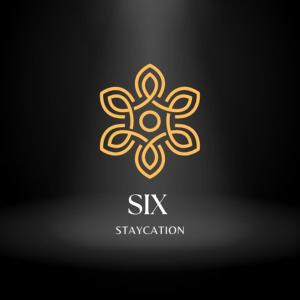 a gold logo with a flower on a black background at SiX Staycation in Kuching
